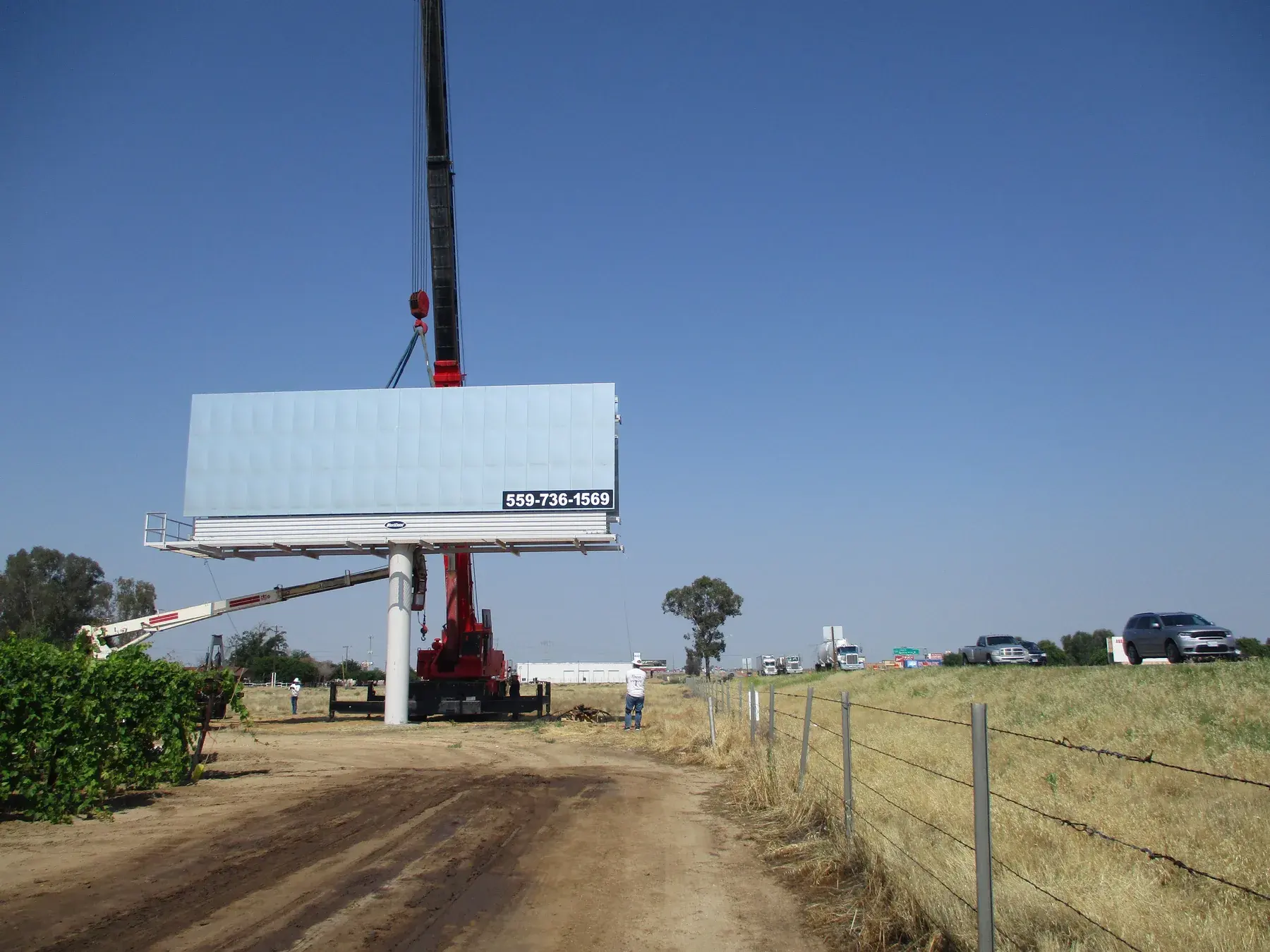 Billboard face being positioned beside an active highway